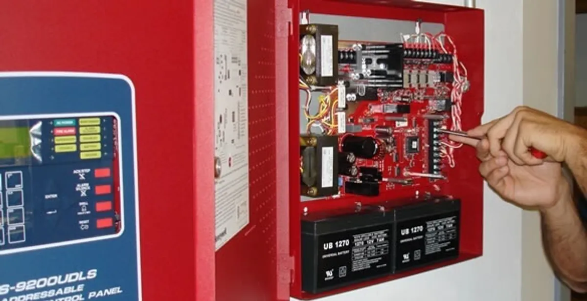 fire alarm installation service showing technician configuring fire alarm control panel in Cape Coral, FL