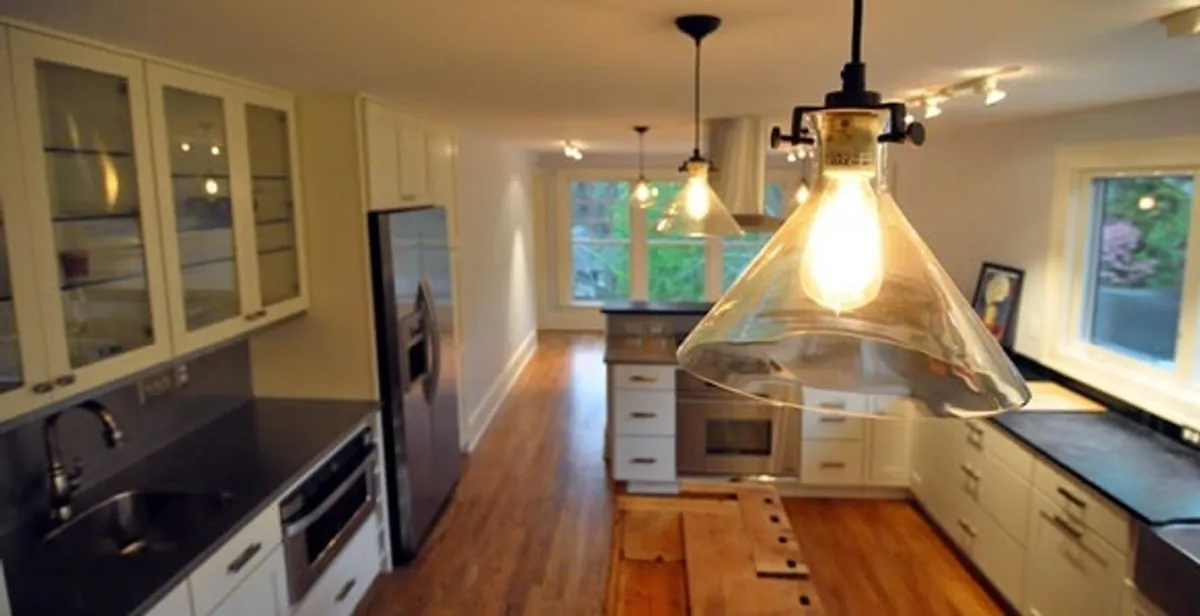 Residential electrician installing modern indoor light fixture in a home in Cape Coral, FL