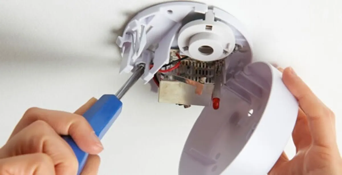 Certified technician wiring smoke detector during installation in Cape Coral, FL